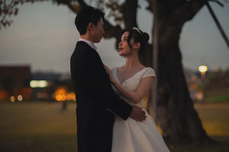 夕暮れの大きな木の下で、見つめ合うおふたり